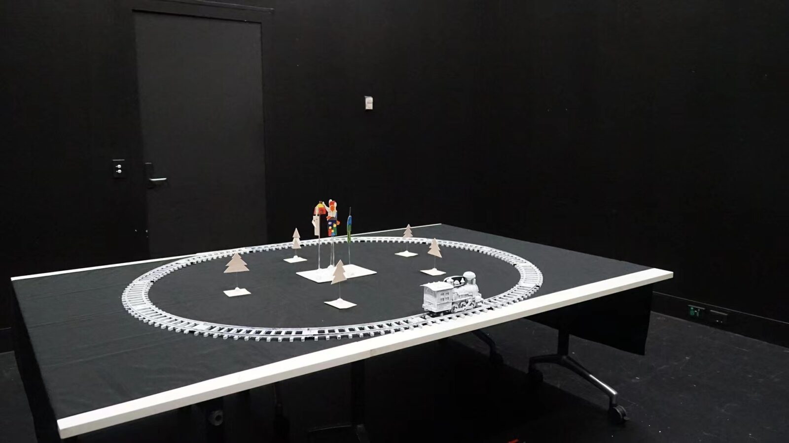 The layout of JOURNEY. It is made of a toy train with a light source, and a middle object.